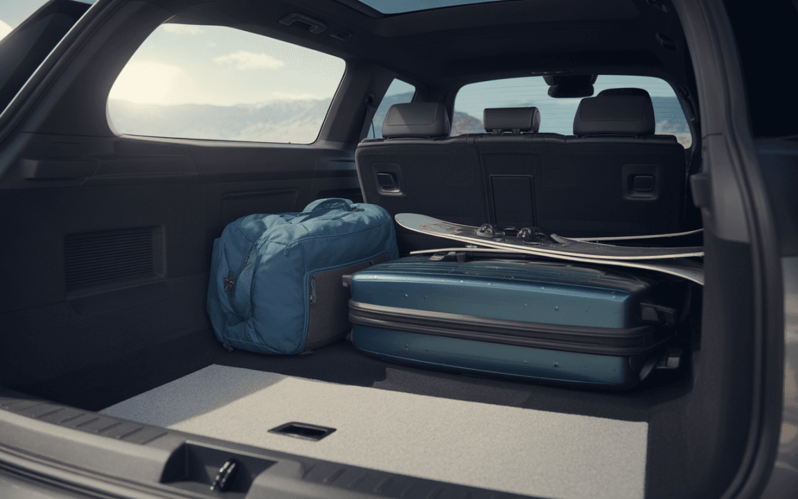 Coffre de voiture avec une valise verte, un sac bleu et des skis. Arrière-plan montagneux et lumineux.