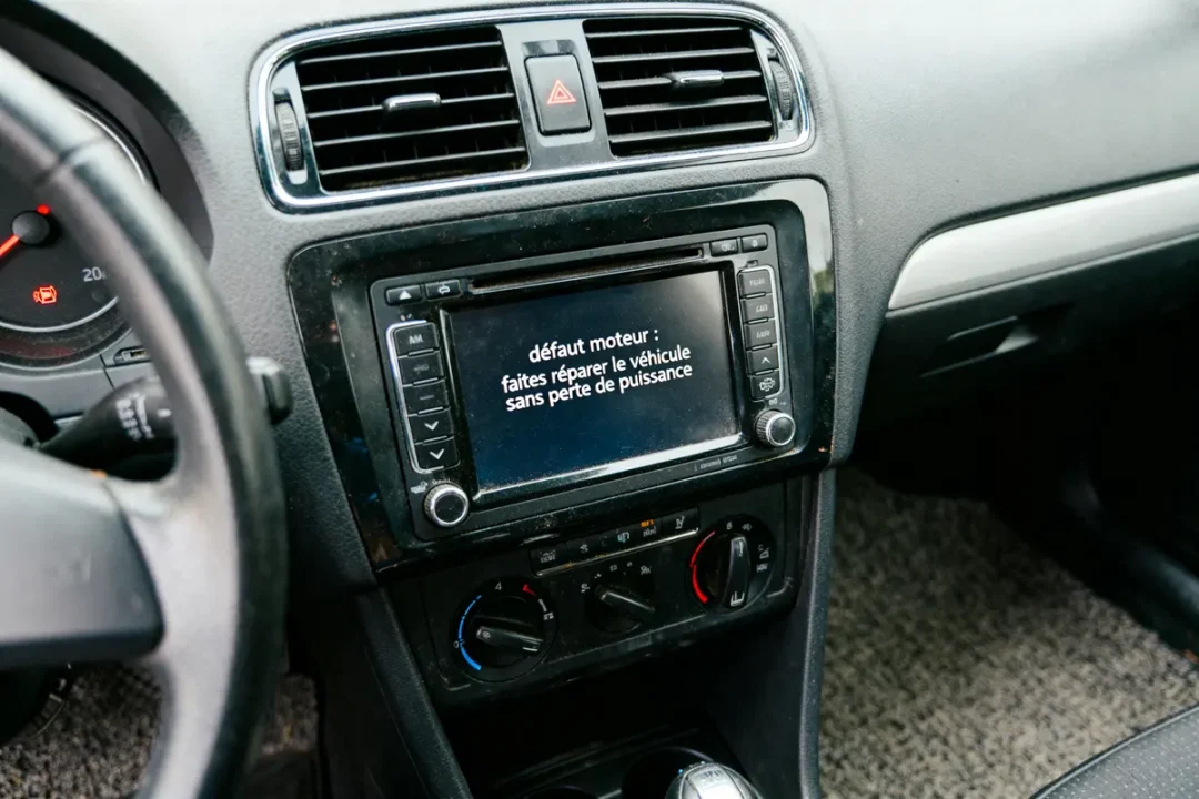 Écran de voiture affichant message de défaut moteur, recommandant réparation pour éviter perte de puissance.