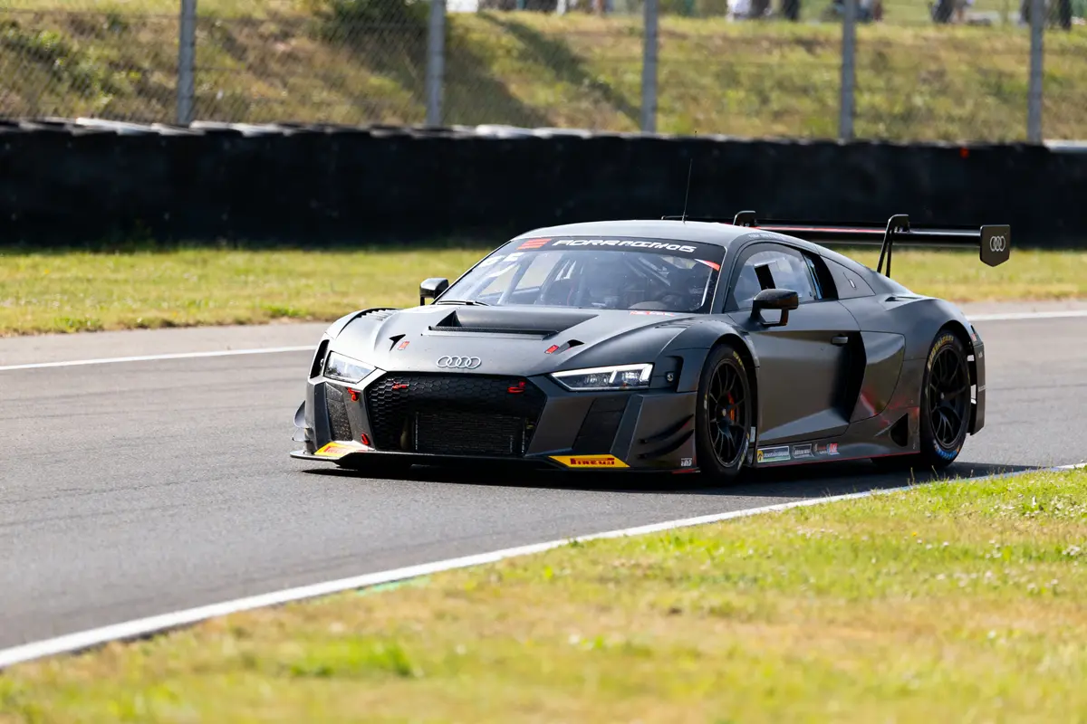 Voiture de course Audi GT2 sur circuit herbeux par temps ensoleillé à pleine vitesse