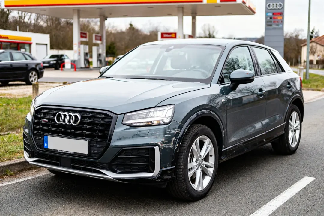 Audi Q2 d'occasion grise stationnée devant une station-service