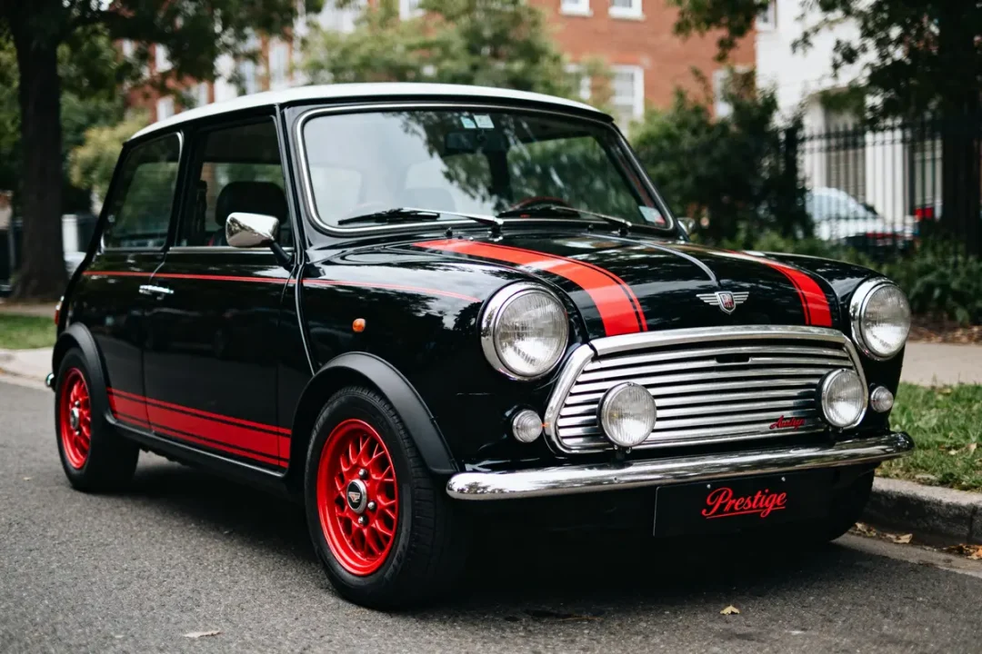 Mini Austin noire classique avec rayures rouges garée en extérieur sur une route