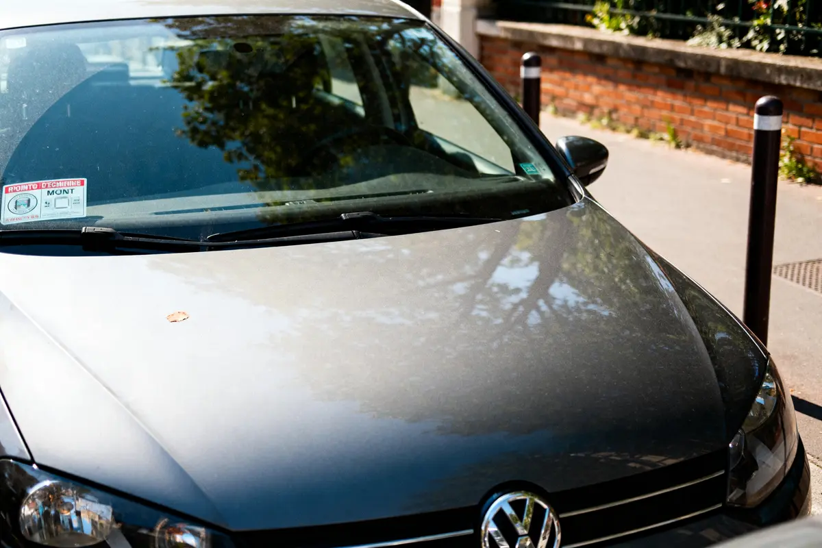 Voiture grise garée avec contrôle technique périmé depuis 1 mois visible sur pare-brise