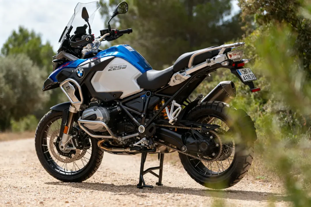 Moto BMW GS 1250 stationnée sur un chemin forestier ensoleillé