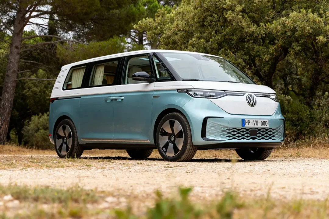 Fourgon Volkswagen ID. Buzz California stationné en forêt sur chemin ensoleillé