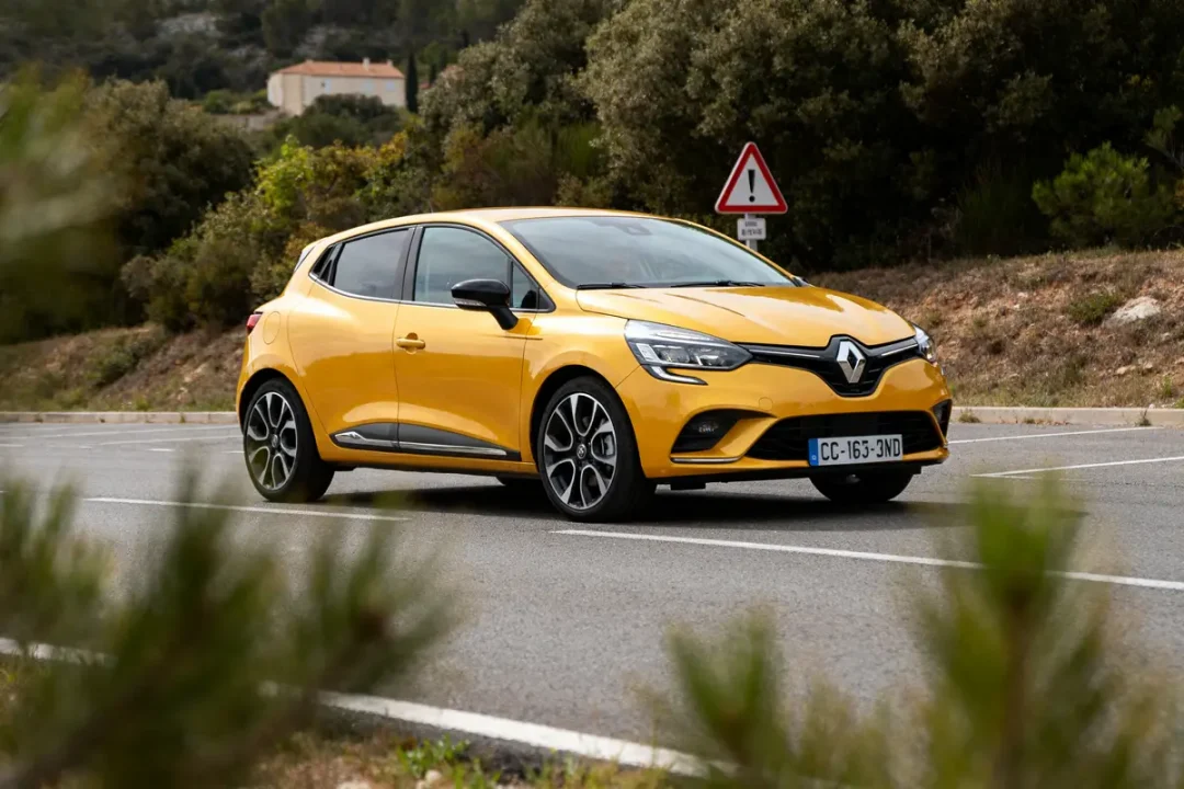 Renault Clio 4 jaune en route avec antipatinage activé et paysage en arrière-plan