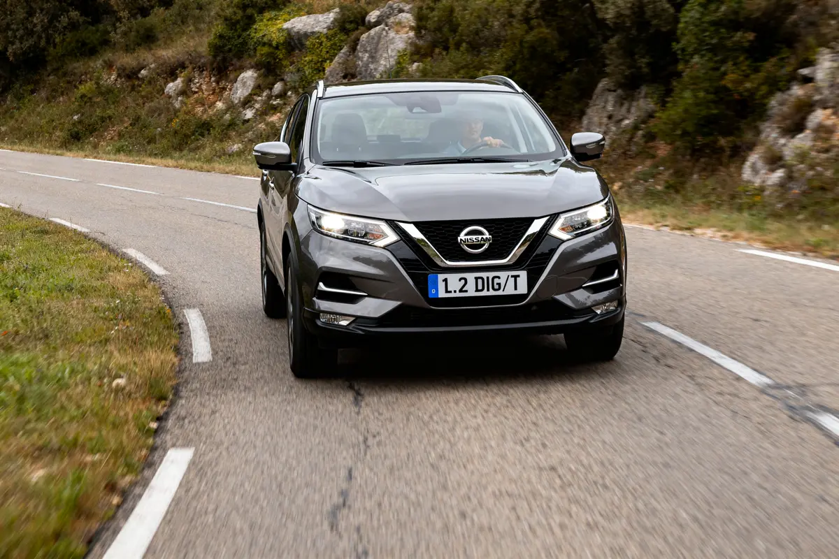 SUV Nissan Qashqai gris sur route sinueuse, vérifiez les modèles de Nissan Qashqai à éviter