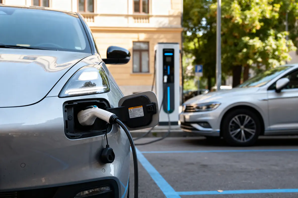 Voiture électrique se rechargeant dans la rue, illustrant le prix de la recharge électrique.