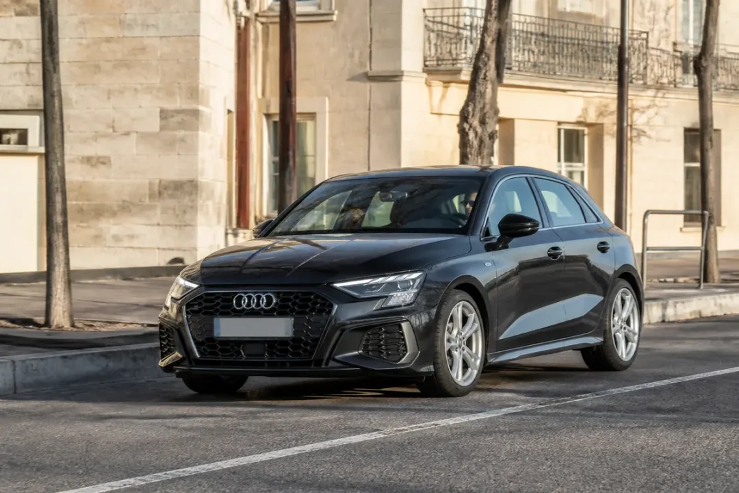 Voiture noire Audi A3 garée en ville près d'un trottoir ensoleillé