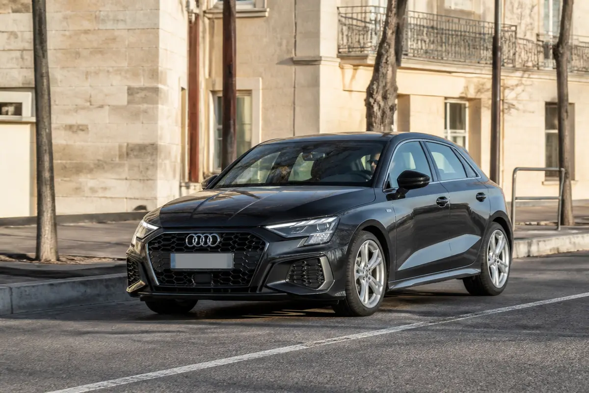 Voiture noire Audi A3 garée en ville près d'un trottoir ensoleillé