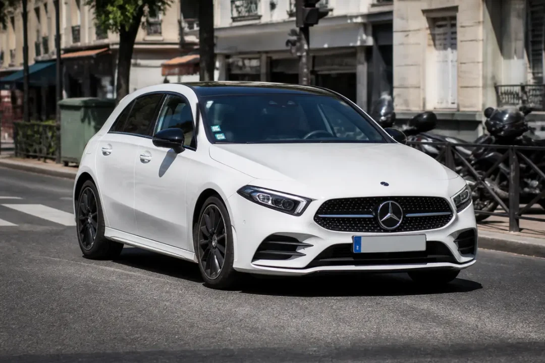 Voiture Mercedes Classe A blanche roulant en ville sur une voie urbaine