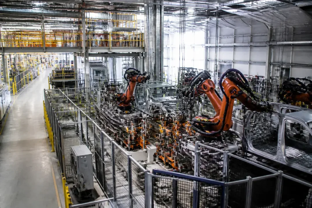 Usine Renault Batilly avec bras robotiques assemblant des véhicules sur une chaîne de production