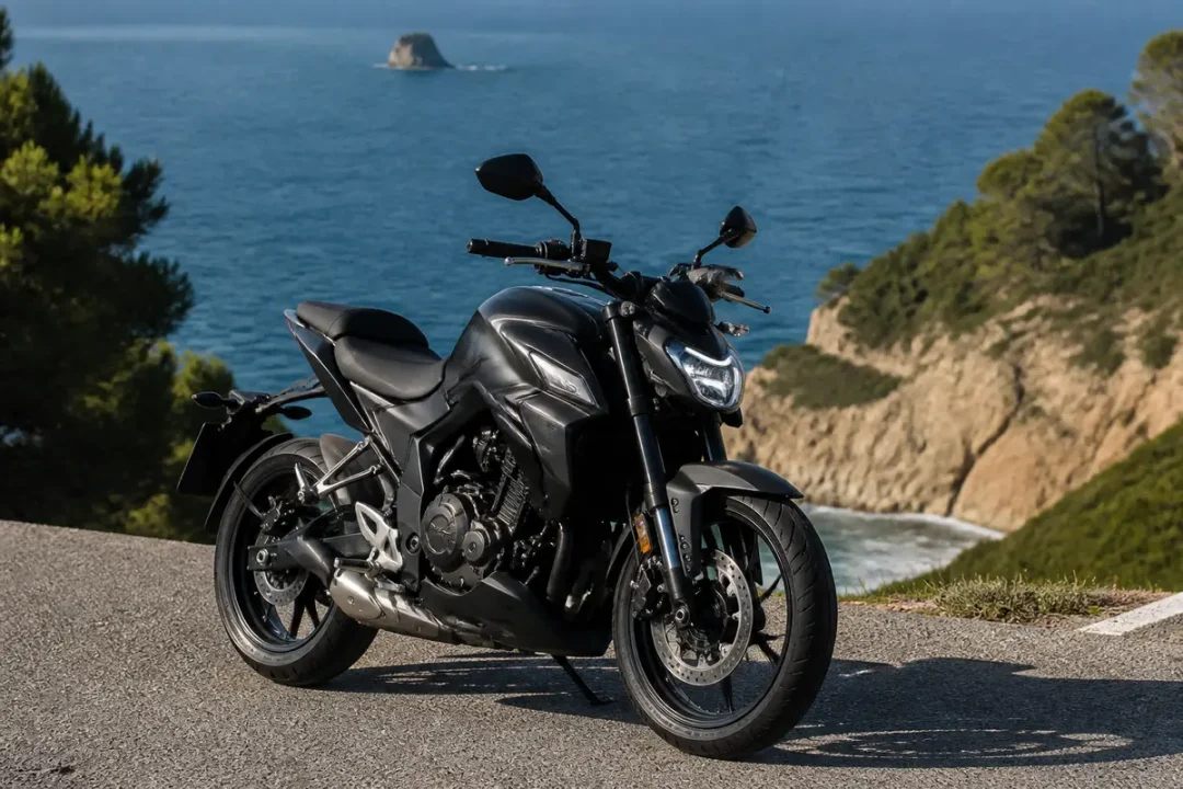Moto Zontes 125 noire sur route côtière avec vue mer et falaise verdoyante