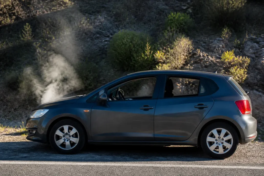 Voiture fumante sur le bord de la route questionnant la conduite avec trop d'huile moteur